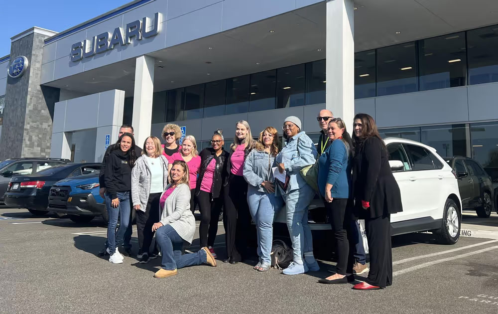 Families posing in front of cars